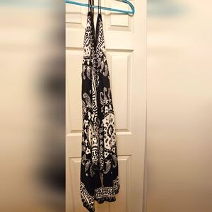 This sundress is black with white print. The dress has straps that tie in back.